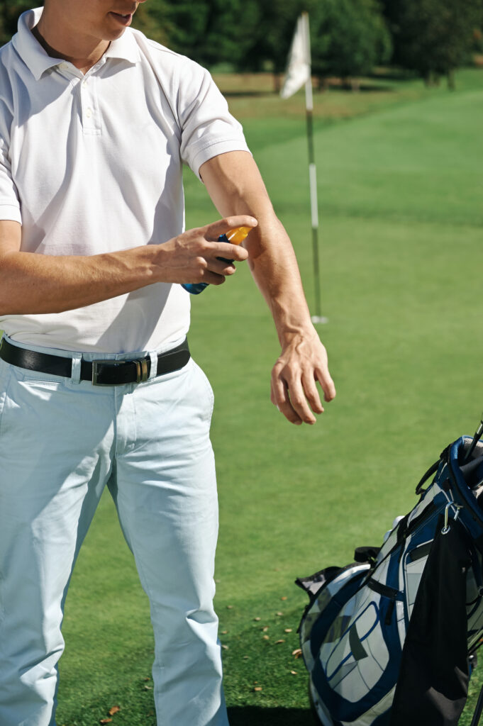 Golfer applying sunscreen