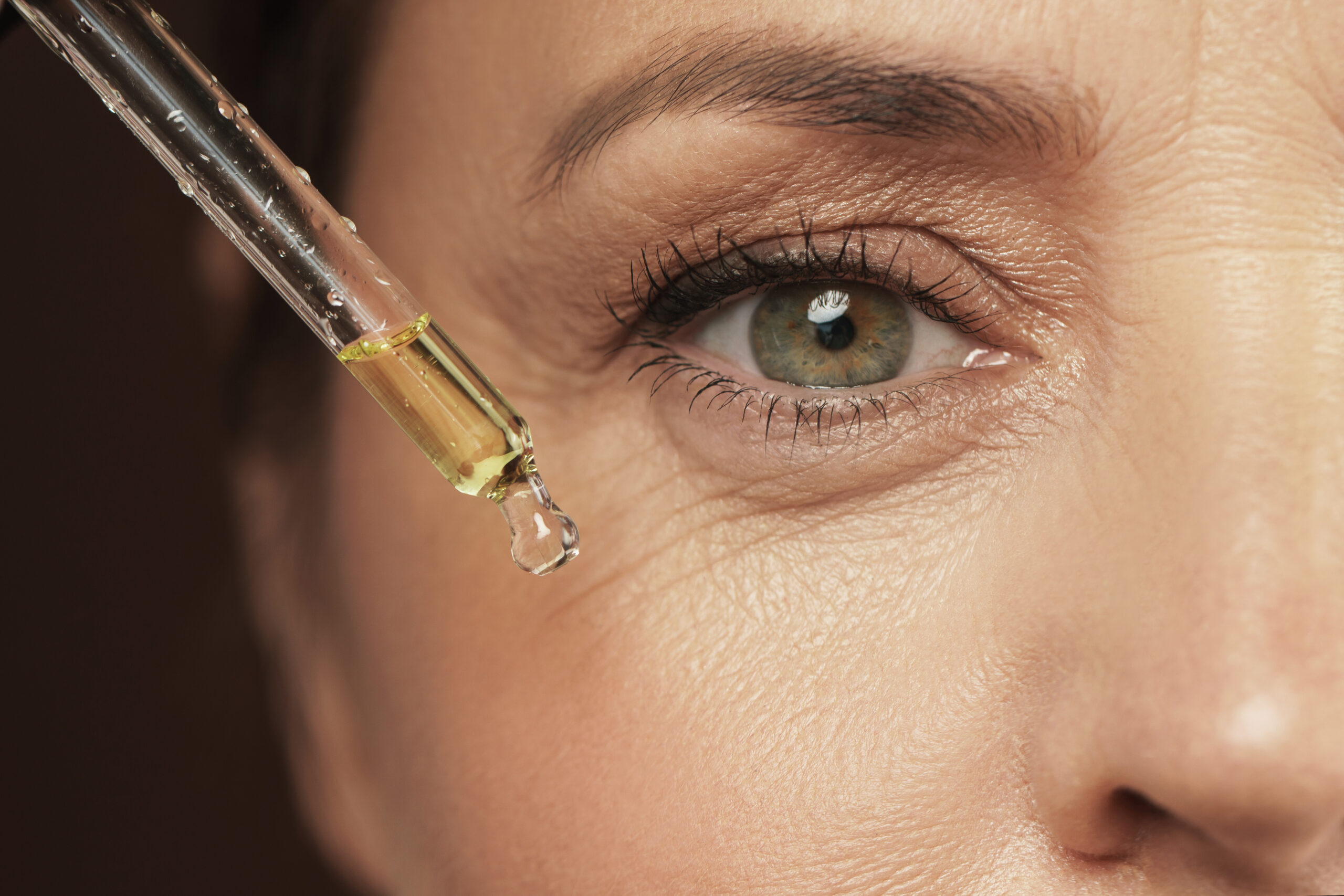 Female eye and dropper with skin serum